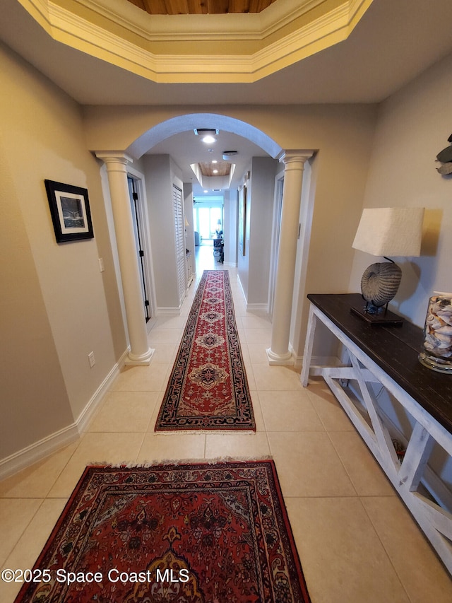 93 Delannoy Ave Unit 601, Cocoa, FL 32922 - hall featuring decorative columns, arched walkways, light tile patterned floors, a tray ceiling, and ornamental molding