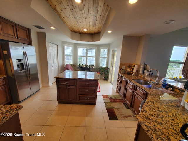 93 Delannoy Ave Unit 601, Cocoa, FL 32922 - kitchen with stainless steel fridge, plenty of natural light, light tile patterned floors, wooden ceiling, and a raised ceiling