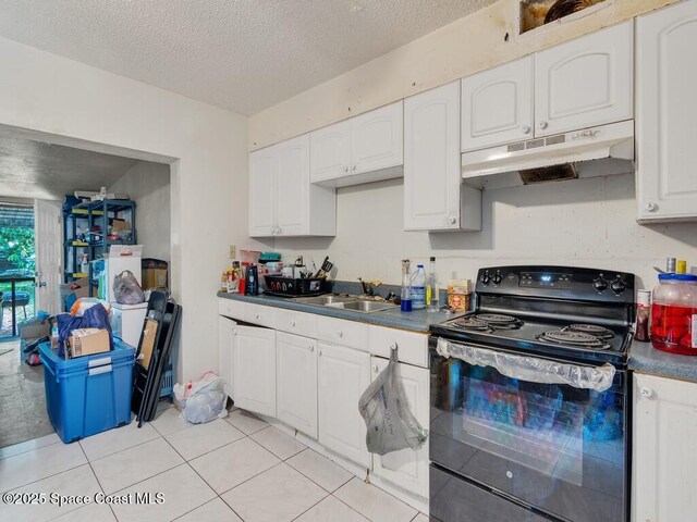 308 N 18th Ct, Ft Pierce, FL 34950 - kitchen featuring black range with electric cooktop, under cabinet range hood, a sink, dark countertops, and white cabinetry