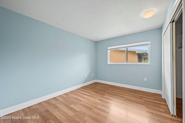 714 Catalina Rd Unit 15, Cocoa Beach, FL 32931 - unfurnished bedroom with a closet, wood finished floors, baseboards, and a textured ceiling