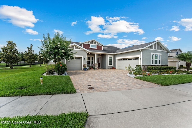14880 Ellingsworth Ln, Winter Garden, FL 34787 - craftsman inspired home featuring a garage, stucco siding, a front lawn, decorative driveway, and stone siding