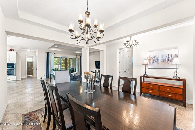 14880 Ellingsworth Ln, Winter Garden, FL 34787 - dining area featuring a chandelier, baseboards, and a tray ceiling