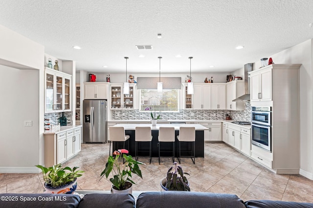 14880 Ellingsworth Ln, Winter Garden, FL 34787 - kitchen with stainless steel appliances, a kitchen island, a kitchen bar, backsplash, and recessed lighting