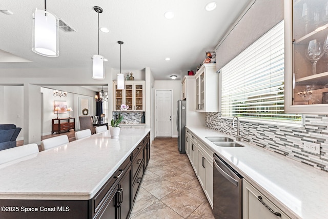 14880 Ellingsworth Ln, Winter Garden, FL 34787 - kitchen with a sink, appliances with stainless steel finishes, decorative backsplash, a center island, and hanging light fixtures