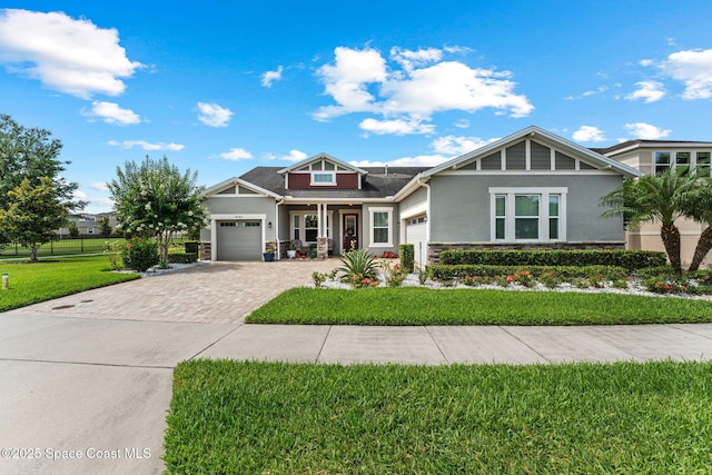 14880 Ellingsworth Ln, Winter Garden, FL 34787 - craftsman house with stone siding, decorative driveway, a garage, and stucco siding