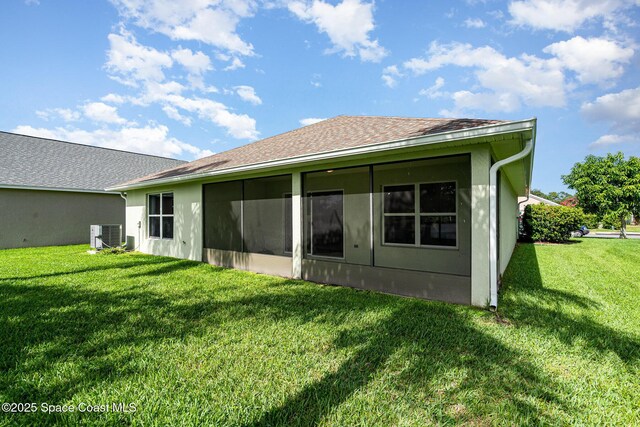 1102 Bainbury Ln, Melbourne, FL 32904 - back of house with a yard, a shingled roof, a sunroom, and stucco siding