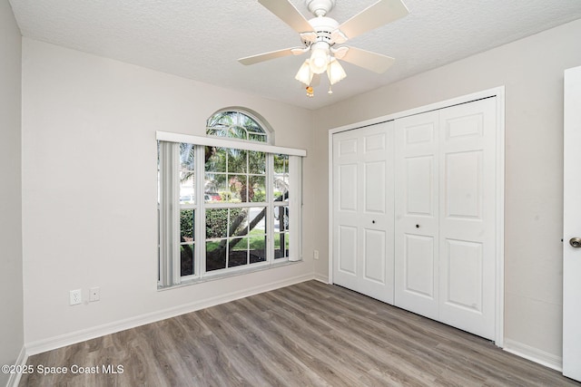 1102 Bainbury Ln, Melbourne, FL 32904 - unfurnished bedroom with wood finished floors, a closet, a textured ceiling, and ceiling fan
