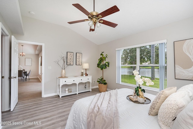 1102 Bainbury Ln, Melbourne, FL 32904 - bedroom with wood finished floors, vaulted ceiling, a chandelier, ceiling fan, and a water view