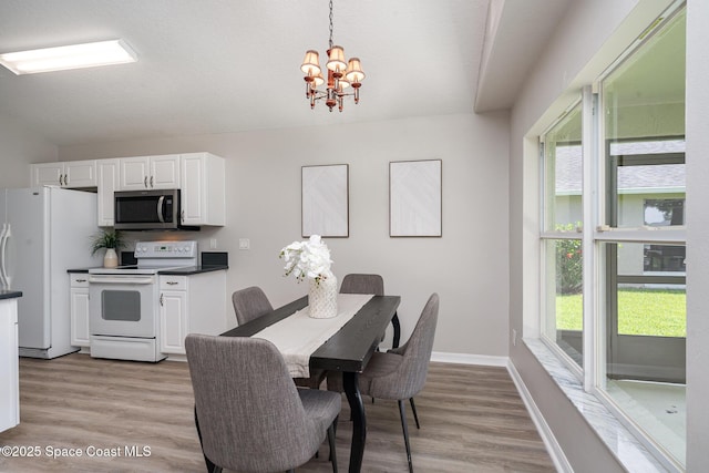 1102 Bainbury Ln, Melbourne, FL 32904 - dining area featuring a chandelier, light wood-type flooring, and lofted ceiling