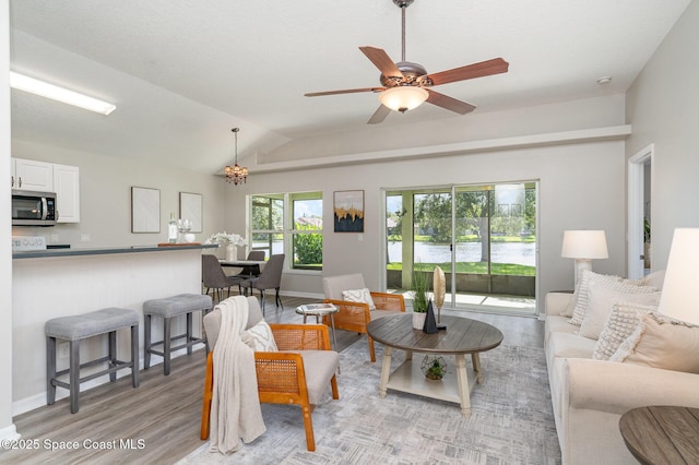 1102 Bainbury Ln, Melbourne, FL 32904 - living room with light wood finished floors, vaulted ceiling, a chandelier, and a ceiling fan