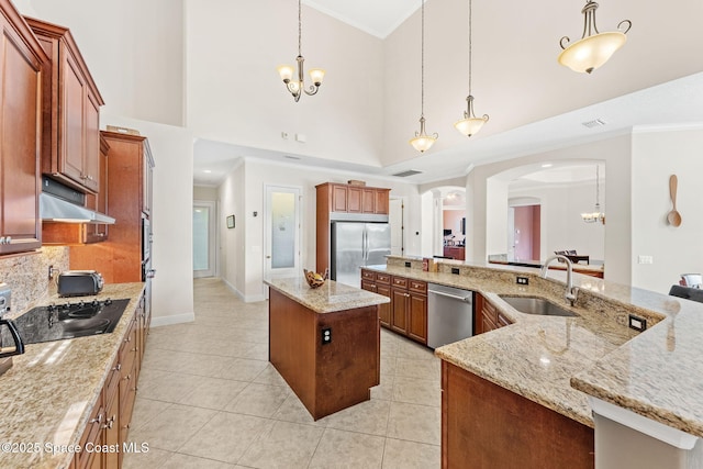 4022 Tradewinds Trl, Merritt Island, FL 32953 - kitchen featuring stainless steel appliances, a large island, a chandelier, arched walkways, and ornamental molding