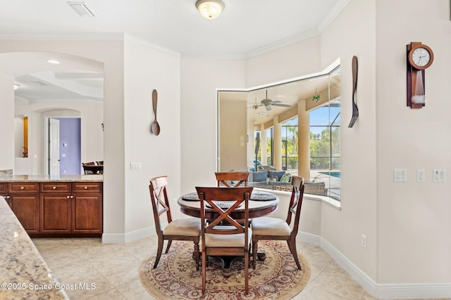 4022 Tradewinds Trl, Merritt Island, FL 32953 - dining room with light tile patterned flooring, a ceiling fan, ornamental molding, and arched walkways