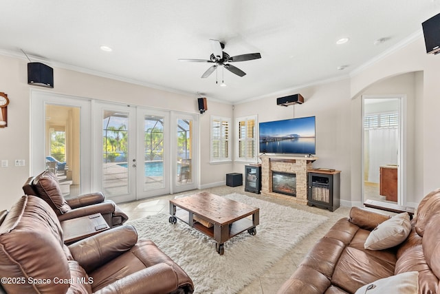 4022 Tradewinds Trl, Merritt Island, FL 32953 - living room featuring tile patterned flooring, a ceiling fan, arched walkways, a fireplace, and crown molding