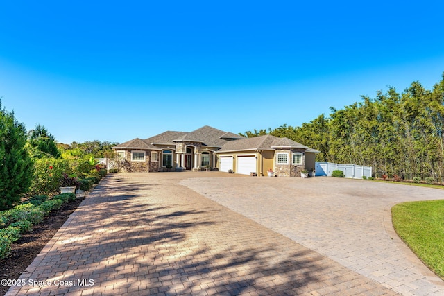 4022 Tradewinds Trl, Merritt Island, FL 32953 - french provincial home with an attached garage, stone siding, decorative driveway, and stucco siding