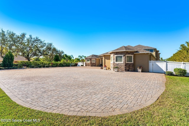 4022 Tradewinds Trl, Merritt Island, FL 32953 - view of front of home featuring stone siding, stucco siding, and a gate
