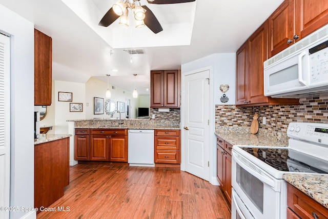 8700 Ridgewood Ave Unit Ph2B, Cape Canaveral, FL 32920 - kitchen with white appliances, brown cabinetry, ceiling fan, wood finished floors, and a sink