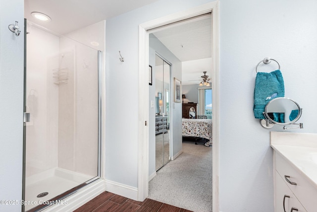 8700 Ridgewood Ave Unit Ph2B, Cape Canaveral, FL 32920 - ensuite bathroom featuring vanity, a stall shower, wood finished floors, and ceiling fan