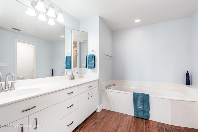 8700 Ridgewood Ave Unit Ph2B, Cape Canaveral, FL 32920 - bathroom with double vanity, a garden tub, wood finished floors, and recessed lighting