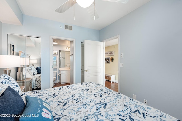 8700 Ridgewood Ave Unit Ph2B, Cape Canaveral, FL 32920 - bedroom with wood finished floors, ceiling fan, and ensuite bathroom