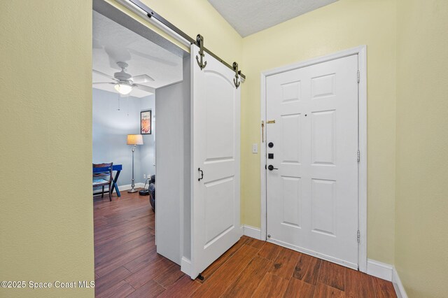 8700 Ridgewood Ave Unit Ph2B, Cape Canaveral, FL 32920 - foyer featuring a barn door, dark wood finished floors, and a ceiling fan
