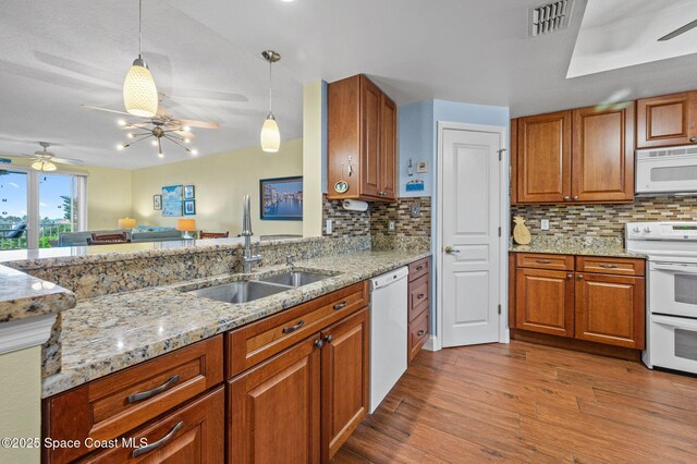 8700 Ridgewood Ave Unit Ph2B, Cape Canaveral, FL 32920 - kitchen with white appliances, ceiling fan, wood finished floors, and brown cabinets