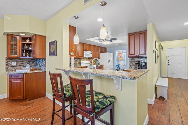 8700 Ridgewood Ave Unit Ph2B, Cape Canaveral, FL 32920 - kitchen with white appliances, decorative backsplash, dark wood finished floors, and recessed lighting