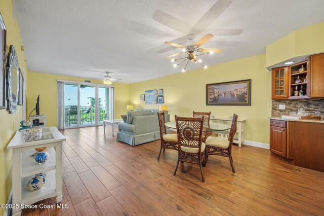 8700 Ridgewood Ave Unit Ph2B, Cape Canaveral, FL 32920 - dining area featuring wood finished floors, ceiling fan, a textured ceiling, and bar area