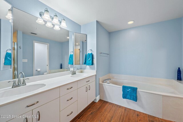 8700 Ridgewood Ave Unit Ph2B, Cape Canaveral, FL 32920 - full bath featuring wood finished floors, a garden tub, and double vanity