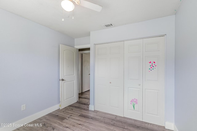 761 Bywood Dr NE, Palm Bay, FL 32905 - unfurnished bedroom with wood finished floors, a closet, and a ceiling fan
