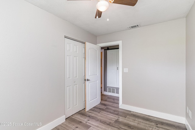761 Bywood Dr NE, Palm Bay, FL 32905 - unfurnished bedroom featuring a closet, wood finished floors, and a ceiling fan