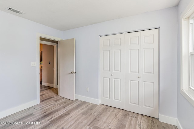 761 Bywood Dr NE, Palm Bay, FL 32905 - unfurnished bedroom with light wood finished floors and a closet
