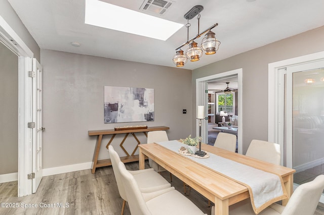761 Bywood Dr NE, Palm Bay, FL 32905 - dining area with light wood-style floors, a skylight, and a chandelier