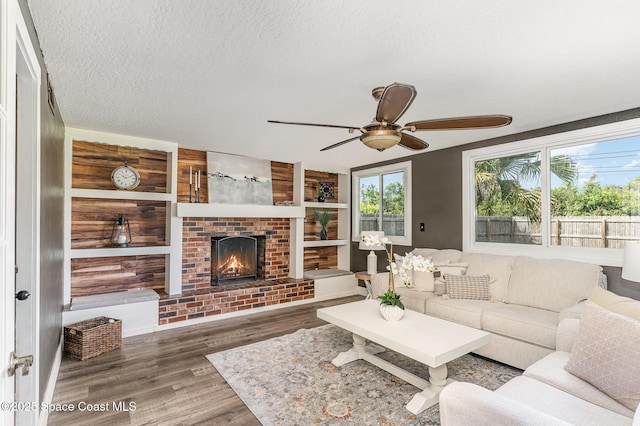 761 Bywood Dr NE, Palm Bay, FL 32905 - living room with ceiling fan, wood finished floors, a brick fireplace, and a textured ceiling