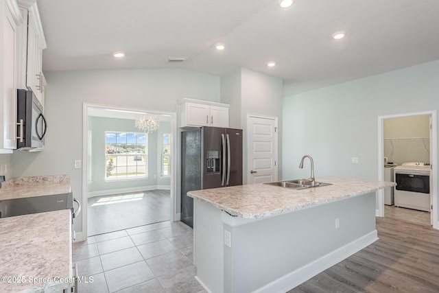 1331 Tupelo Cir, Cocoa, FL 32926 - kitchen featuring a sink, stainless steel appliances, washer and clothes dryer, white cabinetry, and an island with sink