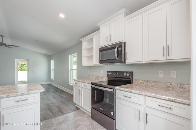 1331 Tupelo Cir, Cocoa, FL 32926 - kitchen with stainless steel microwave, electric range oven, lofted ceiling, a ceiling fan, and white cabinetry