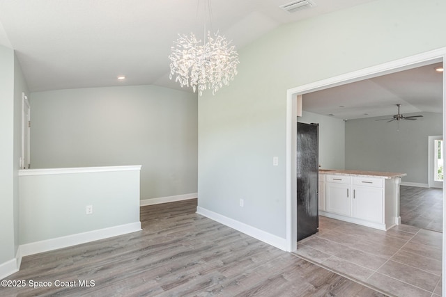 1331 Tupelo Cir, Cocoa, FL 32926 - unfurnished dining area with lofted ceiling, a ceiling fan, light wood-style floors, a chandelier, and baseboards