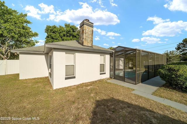 16190 SW 16th Ct, Ocala, FL 34473 - back of property with a chimney, glass enclosure, roof with shingles, and stucco siding