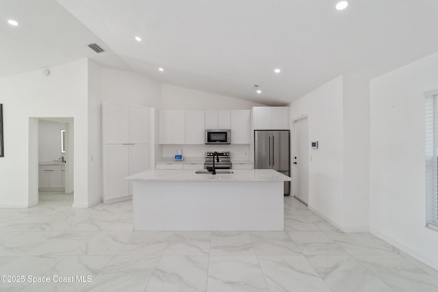 16190 SW 16th Ct, Ocala, FL 34473 - kitchen with stainless steel appliances, a sink, vaulted ceiling, light marble finish floors, and white cabinets