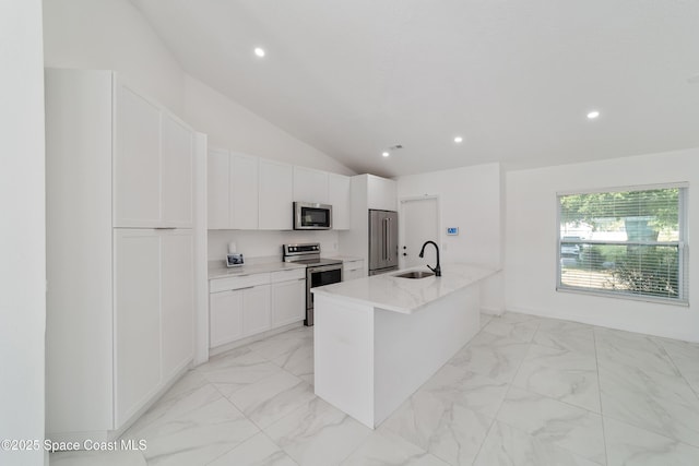 16190 SW 16th Ct, Ocala, FL 34473 - kitchen featuring appliances with stainless steel finishes, a sink, vaulted ceiling, white cabinetry, and light marble finish floors