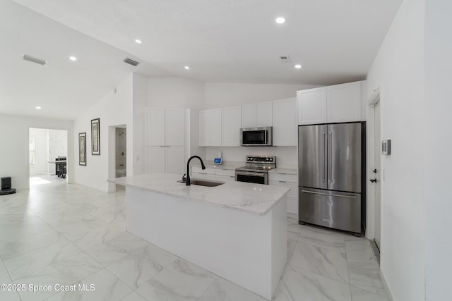 16190 SW 16th Ct, Ocala, FL 34473 - kitchen with appliances with stainless steel finishes, a sink, vaulted ceiling, light marble finish flooring, and white cabinetry