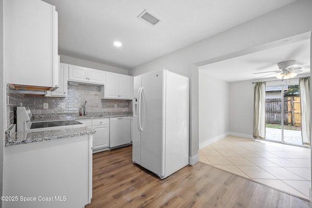 287 Edward Rd, Melbourne, FL 32904 - kitchen featuring white appliances, white cabinets, backsplash, a sink, and ceiling fan