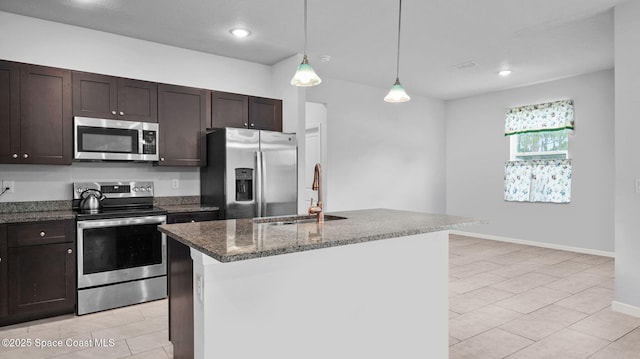 837 Wakaw Ln SW, Palm Bay, FL 32908 - kitchen with appliances with stainless steel finishes, dark brown cabinetry, dark stone counters, decorative light fixtures, and an island with sink