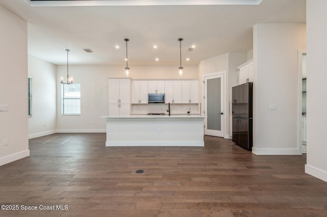 4541 Rosebud St, Cocoa, FL 32927 - kitchen featuring stainless steel microwave, freestanding refrigerator, white cabinets, dark wood-style flooring, and recessed lighting