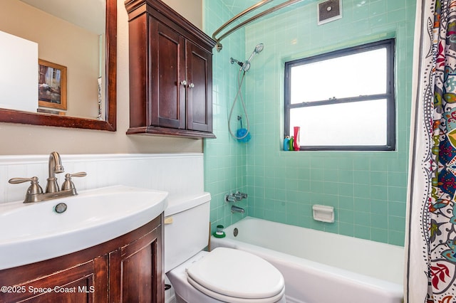 311 3rd St, Merritt Island, FL 32953 - bathroom with shower / tub combo, vanity, toilet, and a wainscoted wall