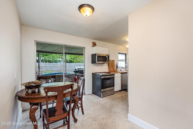 311 3rd St, Merritt Island, FL 32953 - dining space featuring dark aggregate flooring and baseboards