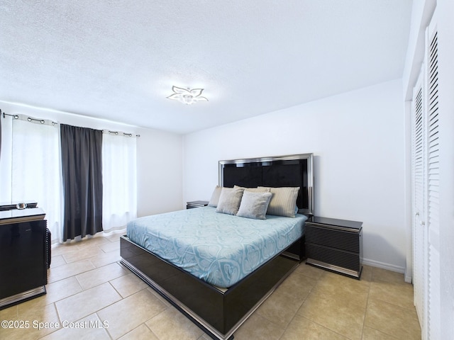 1515 Huntington Ln Unit 924, Rockledge, FL 32955 - bedroom with light tile patterned floors, a closet, baseboards, and a textured ceiling