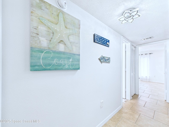 1515 Huntington Ln Unit 924, Rockledge, FL 32955 - hall with tile patterned flooring, a textured ceiling, and baseboards