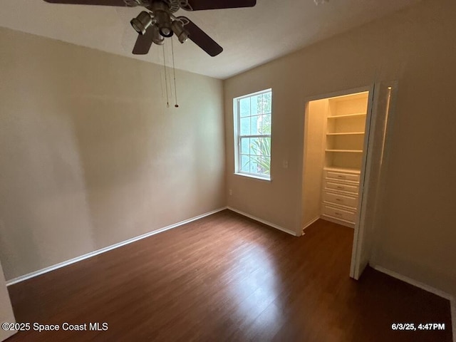 5663 Star Rush Dr Unit 107, Melbourne, FL 32940 - unfurnished bedroom featuring dark wood-type flooring, baseboards, and ceiling fan