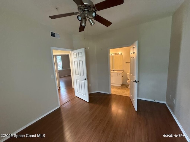 5663 Star Rush Dr Unit 107, Melbourne, FL 32940 - unfurnished bedroom featuring wood finished floors, baseboards, ensuite bath, and a ceiling fan