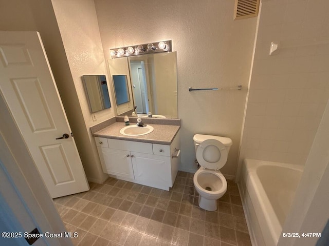 5663 Star Rush Dr Unit 107, Melbourne, FL 32940 - full bath featuring vanity, a textured wall, toilet, tile patterned floors, and baseboards